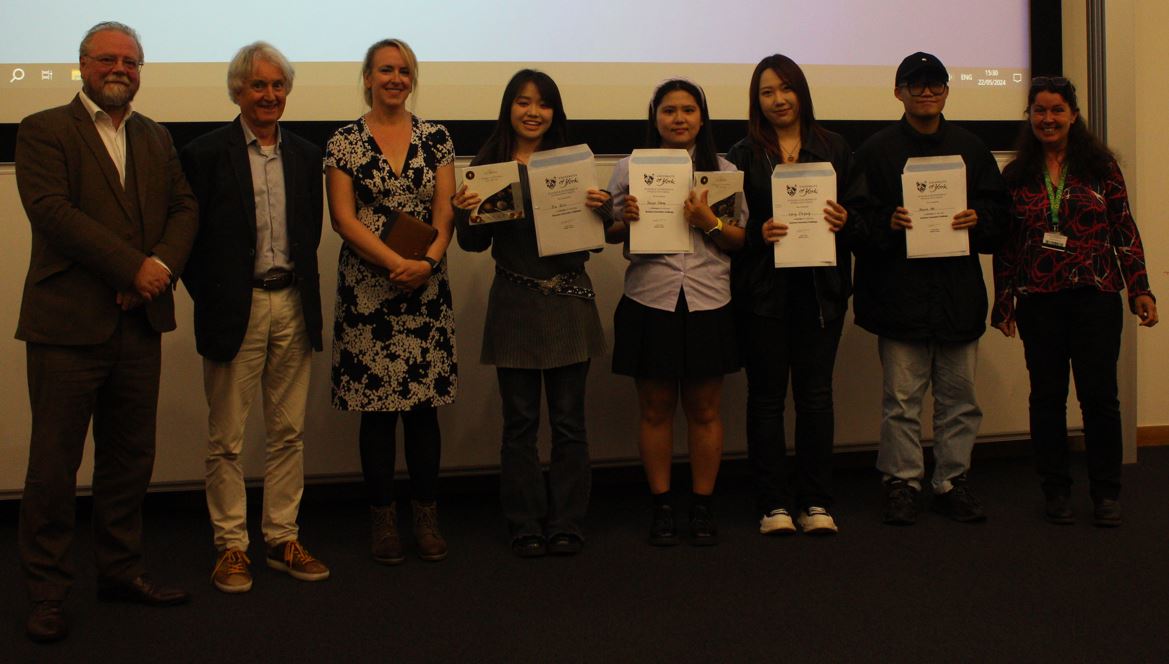 A photo of the 'Culture Unlocked’ group, Xu Guo, Kevin Hu, Senye Zhang, Liang Jiayang standing with Heather Niven and the Dragons Chris Jones, Dick Whittington and Bethany Watrous.